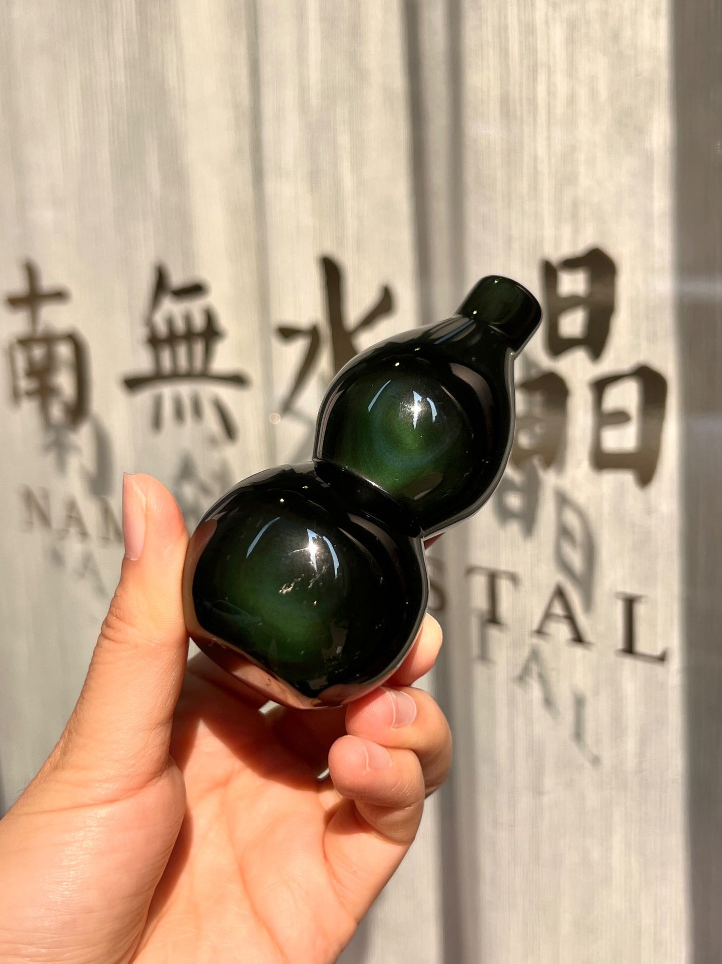 黑曜石壺蘆特寫,展示光線折射出的綠色光帶