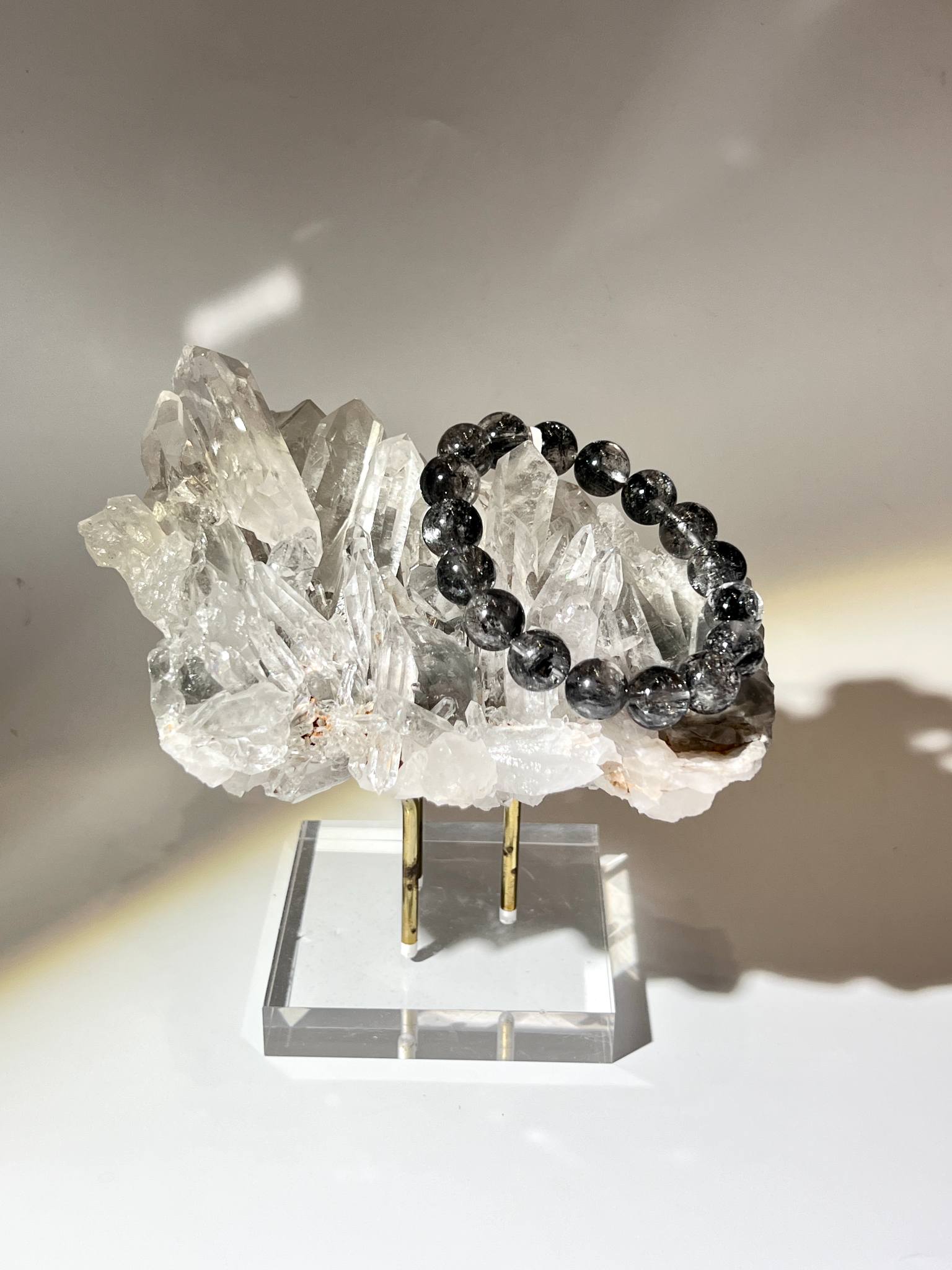 灰藍幽靈列姆利亞水晶原礦擺件，擺放於質感金色展示架，提升現代空間藝術美學。
