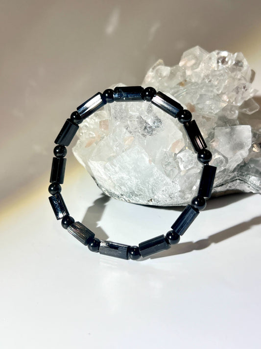 天然莫桑比克黑電氣石手鍊（Black Tourmaline Schorl）放置於白水晶簇前