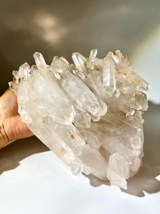 自然光穿透特大雙尖白水晶簇，搭配專屬質感底座，展現現代居家與工作室空間美學。