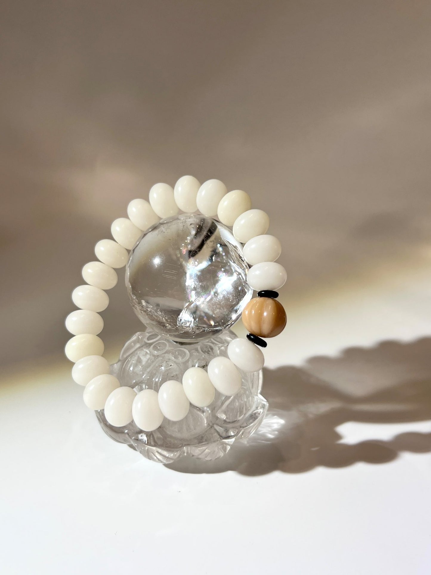 Clear quartz sphere on carved lotus crystal base with natural inclusions