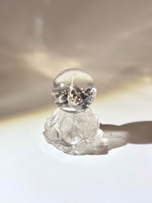 天然白水晶球置於白水晶蓮花雕刻座上，呈現純淨透明光感