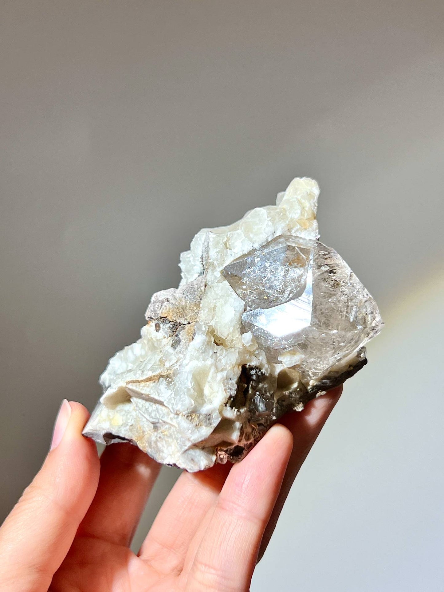 手持美國赫基蒙閃靈鑽母岩感受原生礦物質感與手部對比