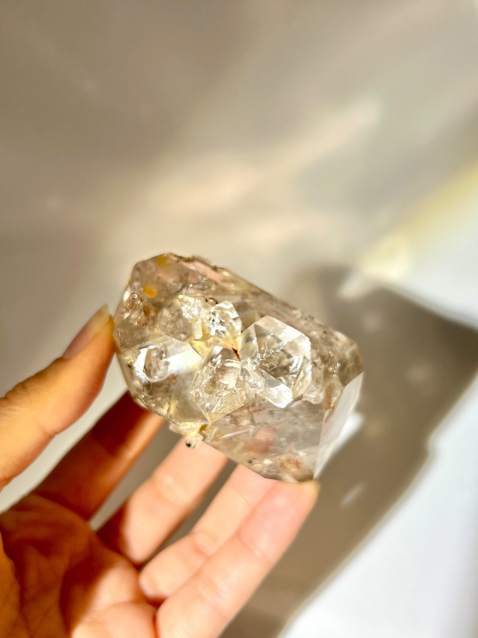 罕有煙茶色 Herkimer Diamond，放置於透明水晶座上。