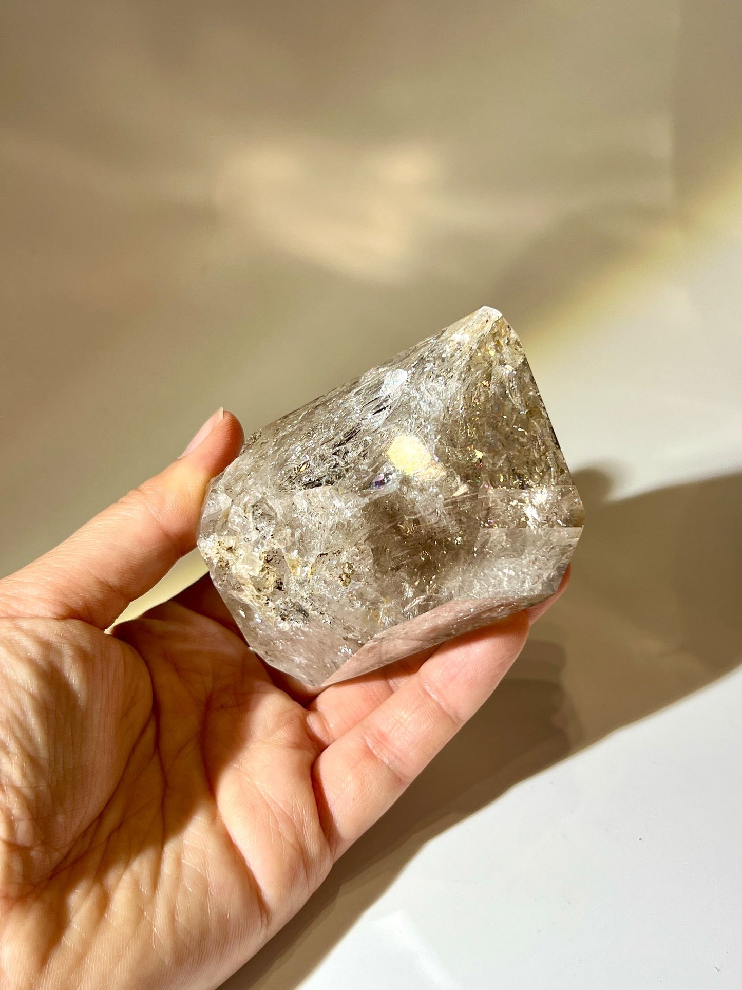 Natural double‑terminated Herkimer Diamond standing on display base with internal ice fractures and light refraction.