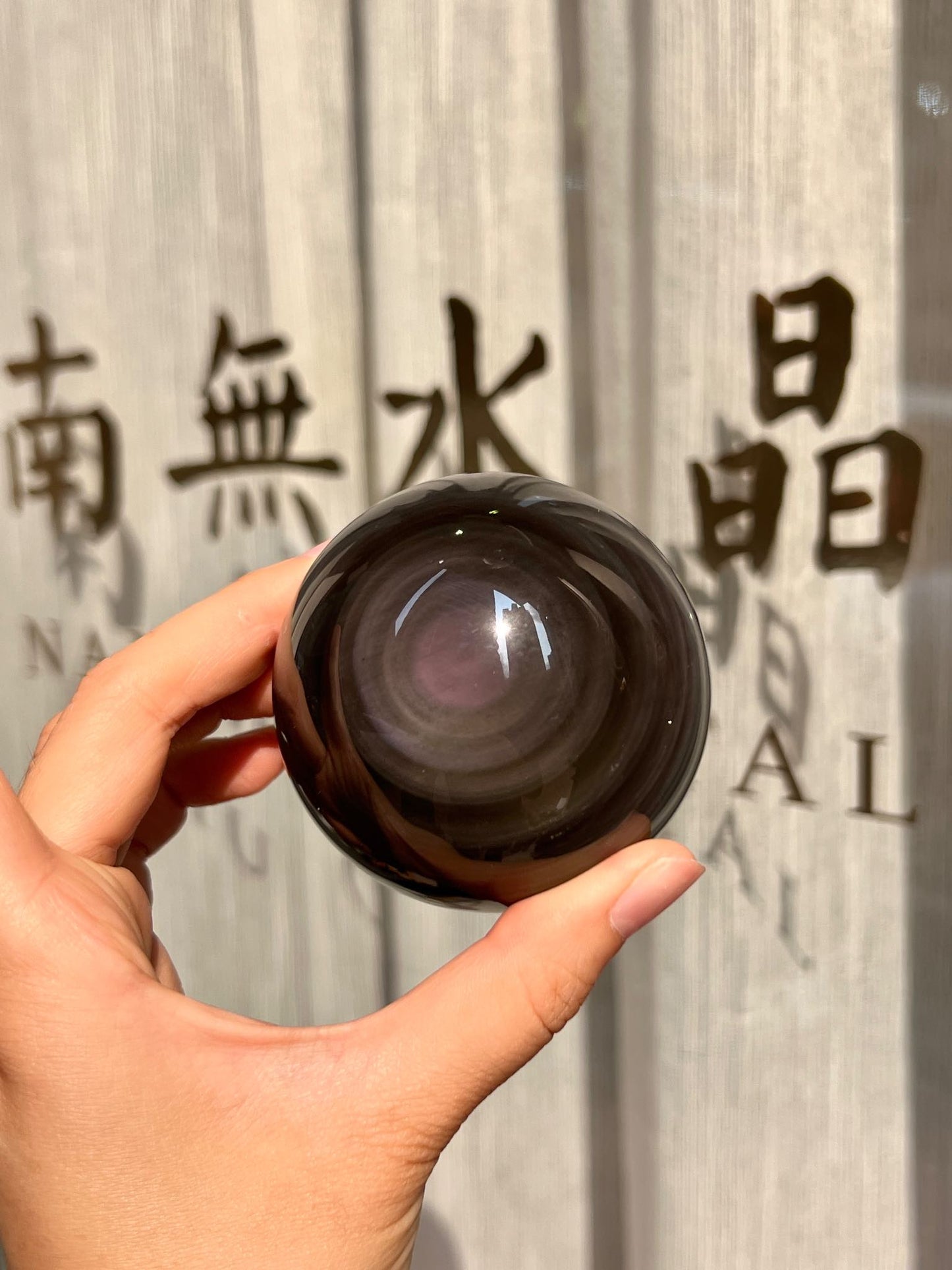黑曜石水晶球特寫，展示光暈與細緻光澤
