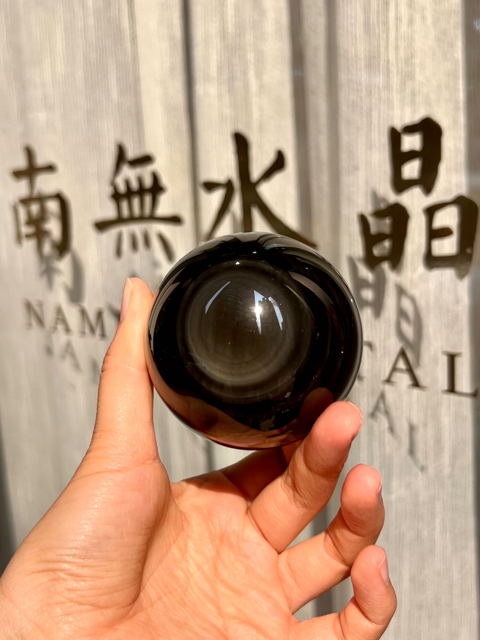 大黑曜石水晶球放在戶外光線下的能量質感展示