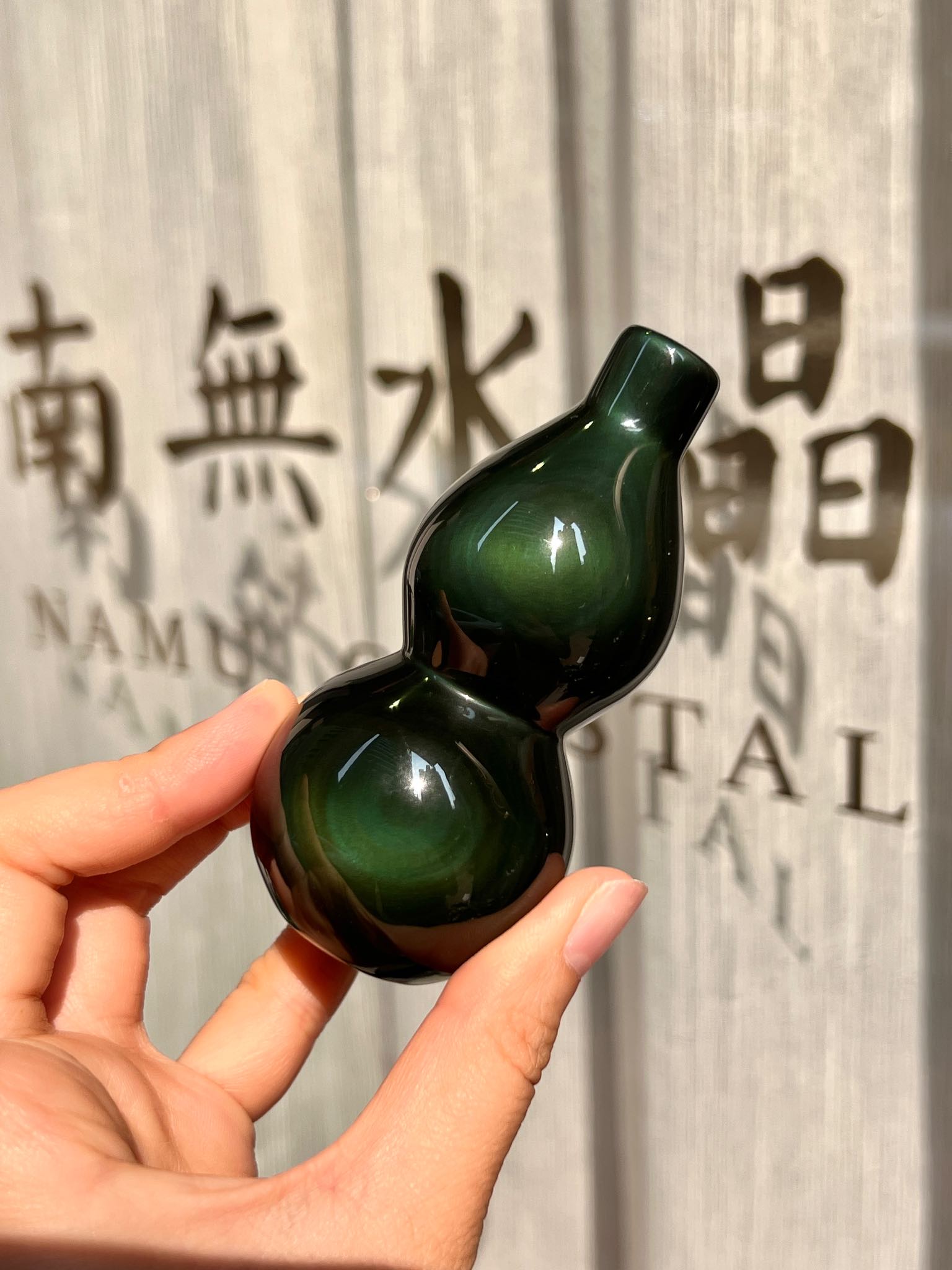 墨綠黑曜石壺蘆在陽光下呈現深綠光暈