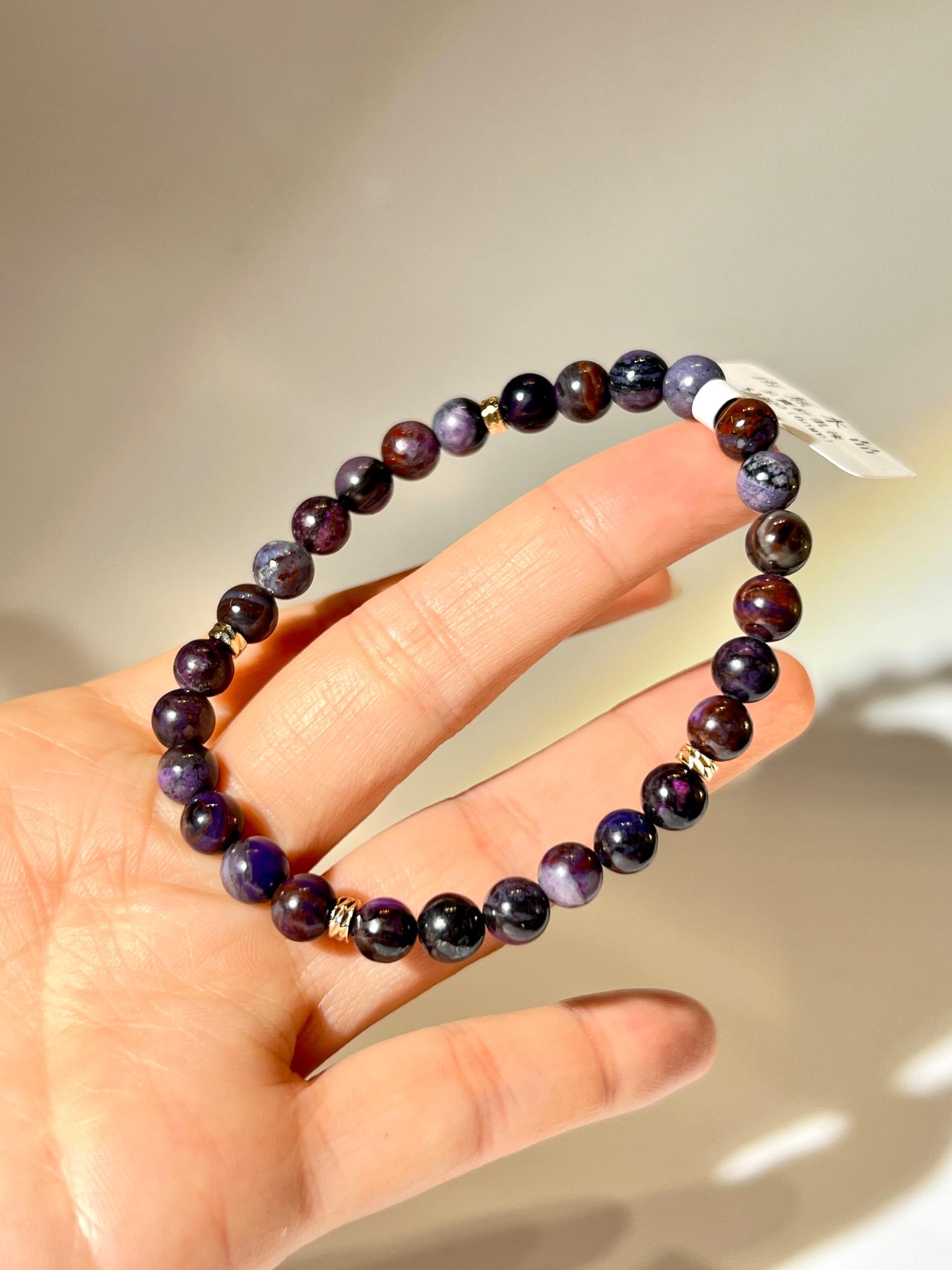 舒俱徠手鏈近拍，展示深紫、玫紫、藍紫與黑紫的天然礦紋細節。